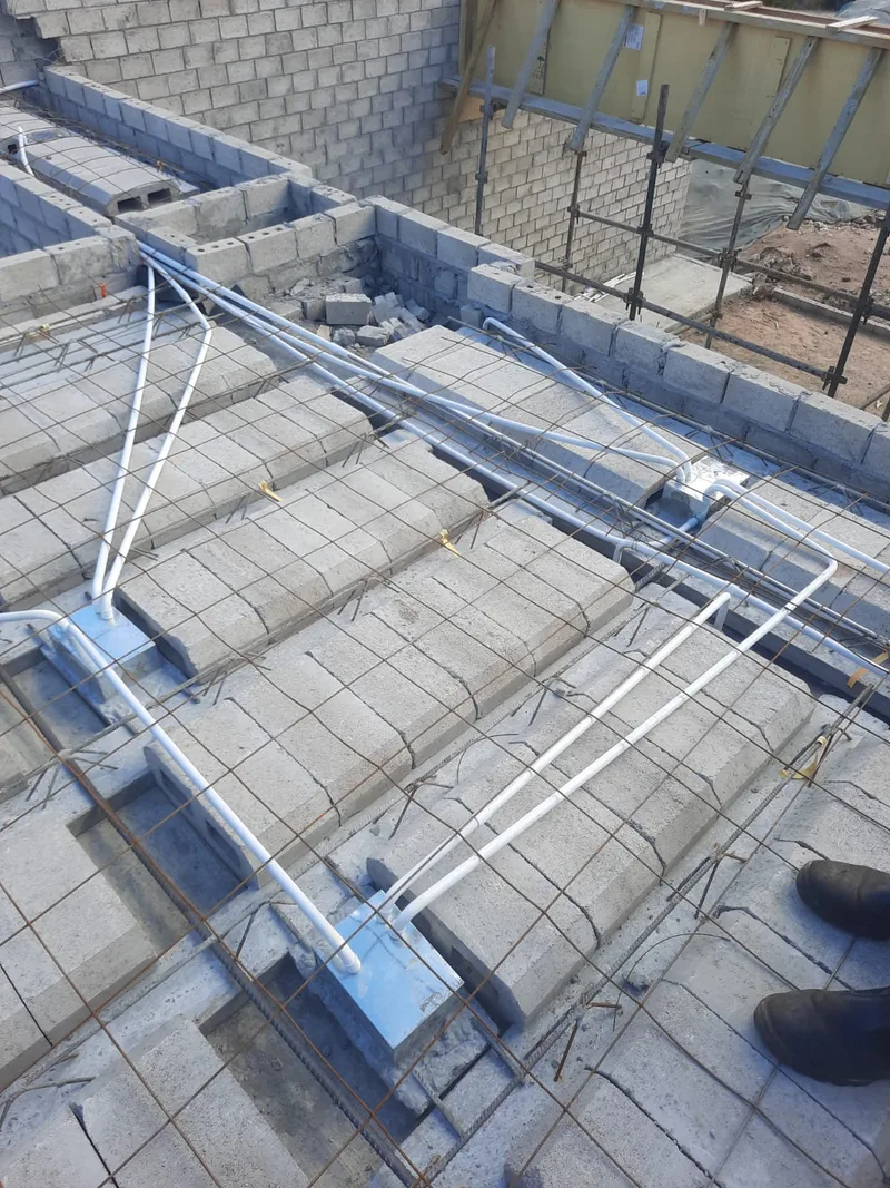 Electrical conduits routed through a block-and-beam floor during construction.