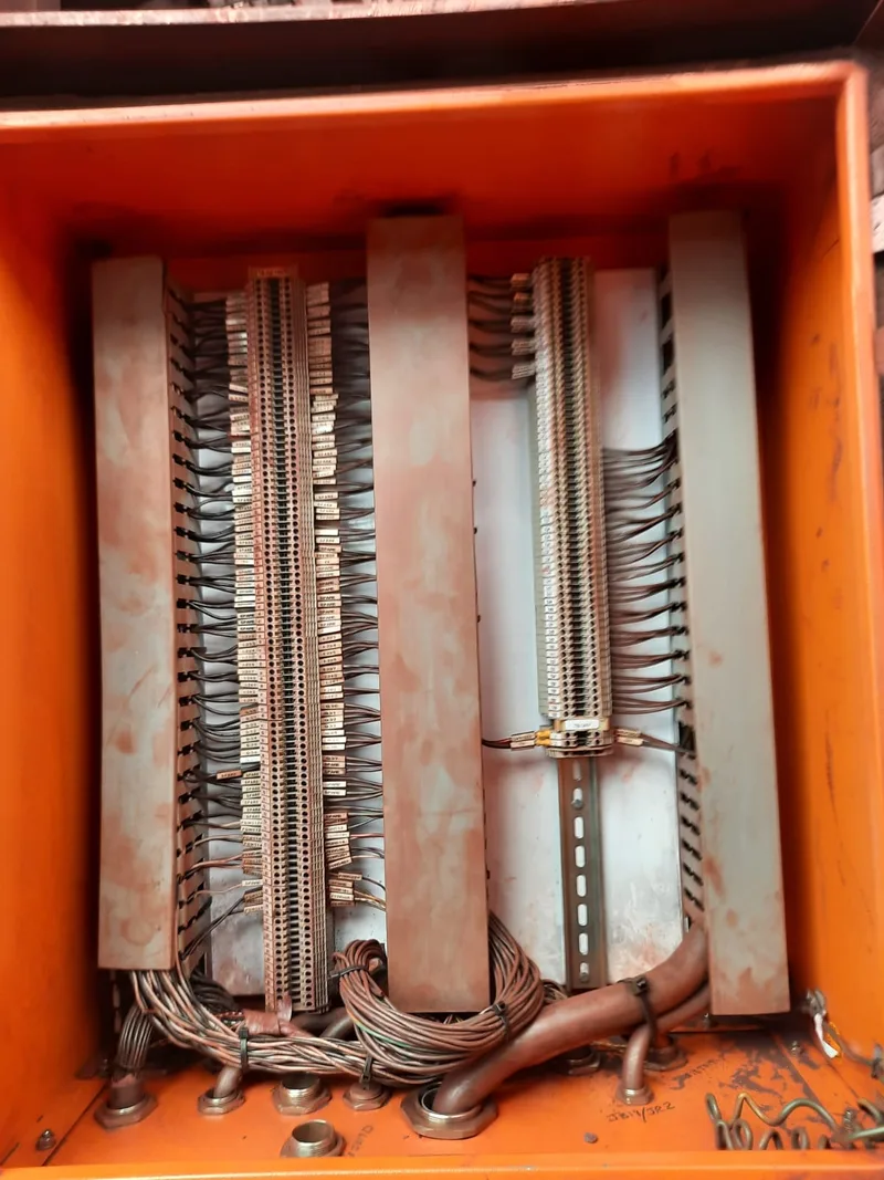 Rows of terminal connections and numbered wiring inside an orange electrical enclosure.